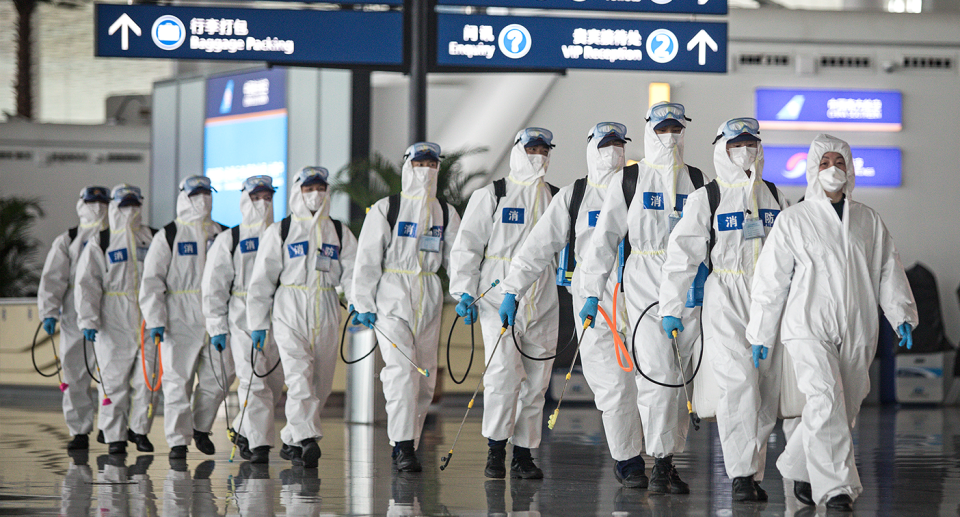 An image of PPE clad workers at an airport in Wuhan, China. 