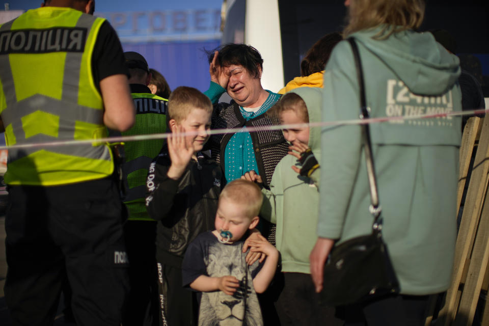 Luda Lobanova, 58, center, cries next to her three grandchildren as they arrive to a reception center for displaced people in Zaporizhzhia, Ukraine, Sunday, May 8, 2022. Volunteer drivers are risking everything to deliver humanitarian aid to Ukrainians behind the front lines of the war — and to help many of them escape. The routes are dangerous and long and the drivers risk detention, injury or death. (AP Photo/Francisco Seco)