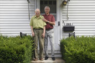 In this Saturday, July 17, 2021, photo, Fred Ware, left, stands outside his home with his son Dave Ware in Manchester, Conn. Fred and Dave Ware recently found a whites-only covenant on his property dating back to 1942 when researching the title chain. Upon finding the covenant, Dave Ware, who grew up in the home, reached out to state lawmakers and helped get a bill passed that strips these covenants on properties. (AP Photo/Jessica Hill)