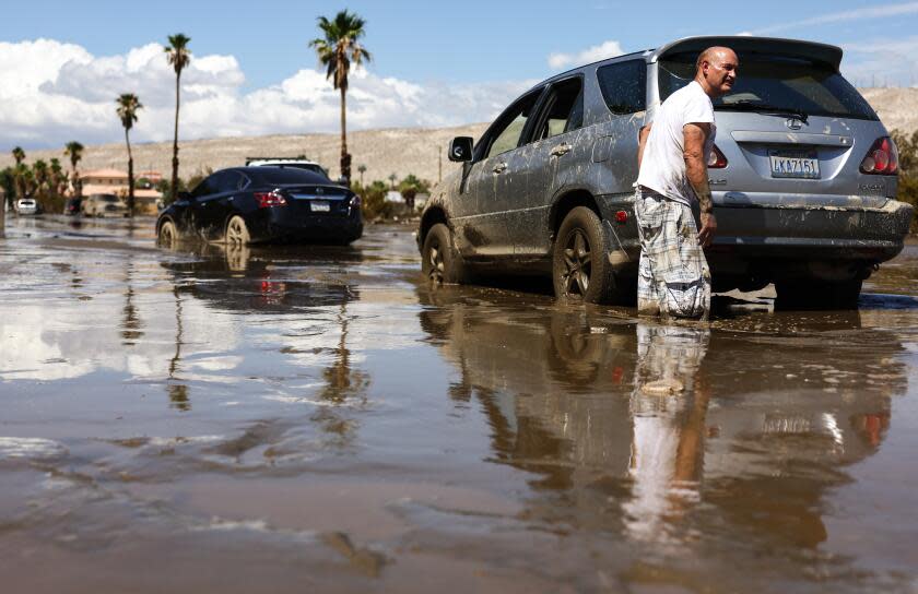 CATHEDRAL CITY, CALIFORNIA - AUGUST 21: A motorist whose car became stranded waits for a a bulldozer to clear mud from a road on August 21, 2023 in Cathedral City, California. Much of Southern California and parts of Arizona and Nevada are cleaning up after being impacted by Tropical Storm Hilary that brought several inches of rain that flooded roadways and winds that toppled trees and power lines across the region. (Photo by Mario Tama/Getty Images)