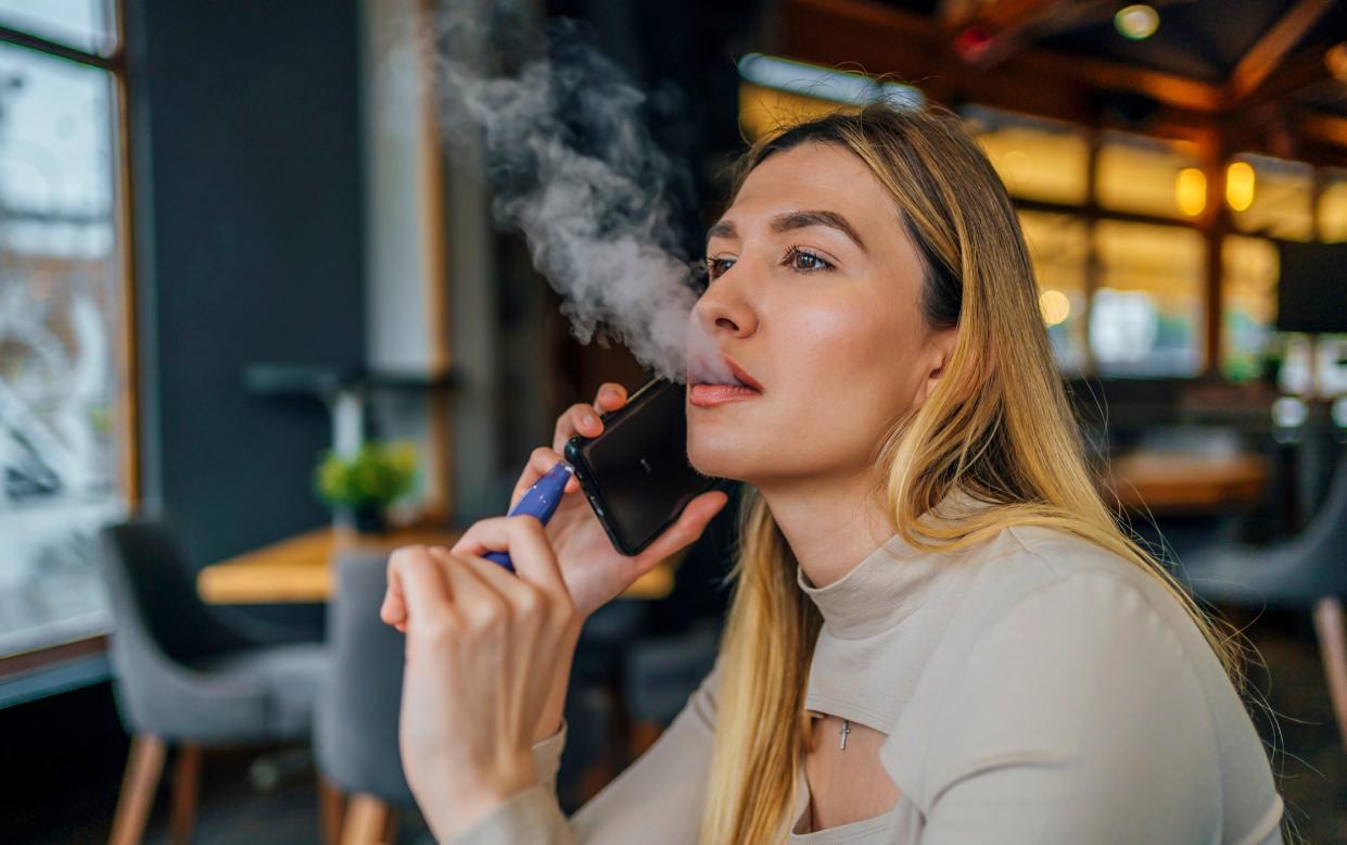 Woman uses disposable vape