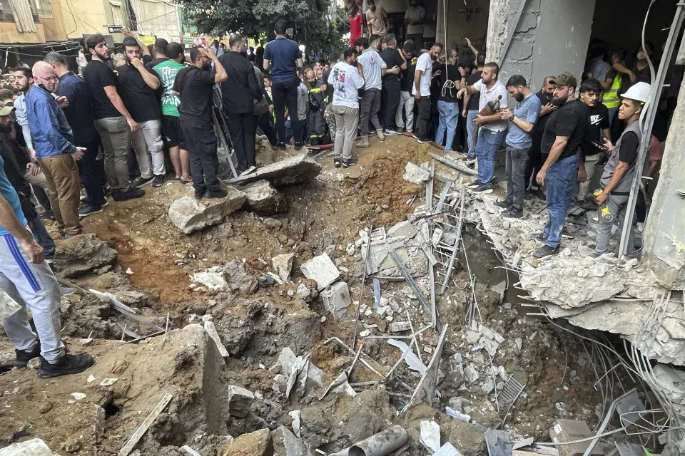 People gather at the scene of an Israeli missile strike in the southern suburbs of Beirut, Friday, Sept. 20, 2024. (AP Photo/Bilal Hussein)