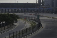 A Police officer crosses a road in front of the Lekki toll gate in Lagos, Nigeria, Wednesday Oct. 21, 2020. After 13 days of protests against alleged police brutality, authorities have imposed a 24-hour curfew in Lagos, Nigeria's largest city, as moves are made to stop growing violence. ( AP Photo/Sunday Alamba)