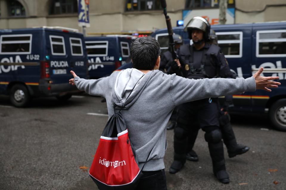 <p>A person confronts police trying to control the area as people head to the ballot box. (Getty) </p>