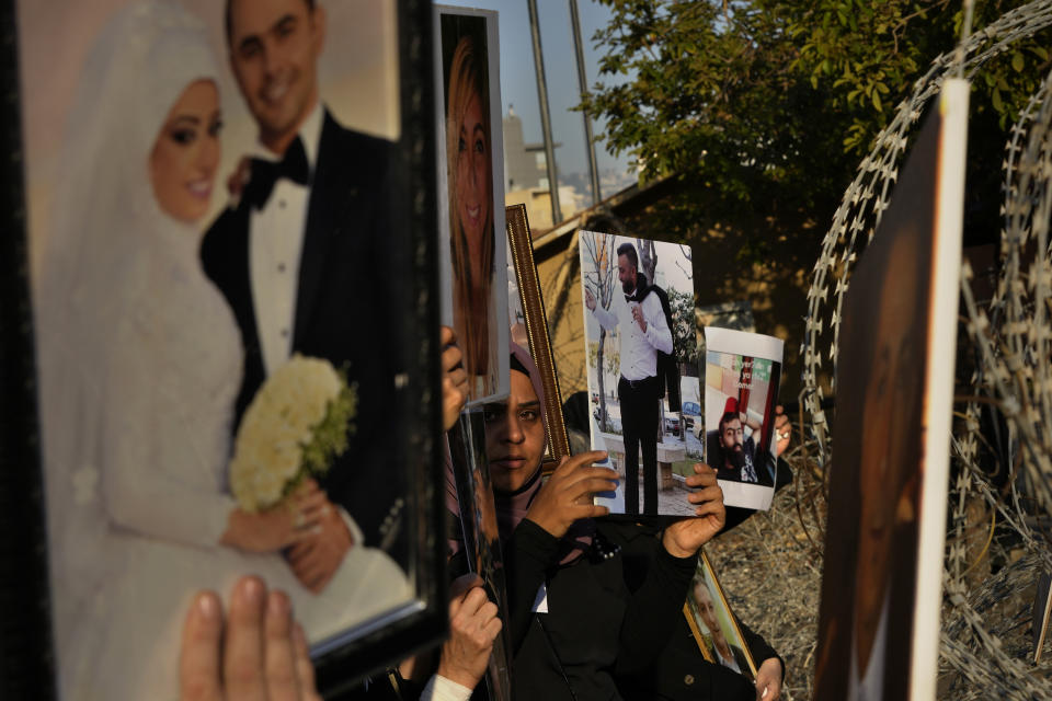 Relatives of victims of the Aug. 4, 2020, Beirut port explosion hold portraits of their loved ones during a protest near the Parliament building to demand an expedited investigation, in Beirut, Lebanon, Sunday, July 4, 2021. A year after the deadly blast, families of the victims are consumed with winning justice for their loved ones and punishing Lebanon's political elite, blamed for causing the disaster through their corruption and neglect. Critics say the political leadership has succeeded so far in stonewalling the judicial investigation into the explosion. (AP Photo/Hassan Ammar)