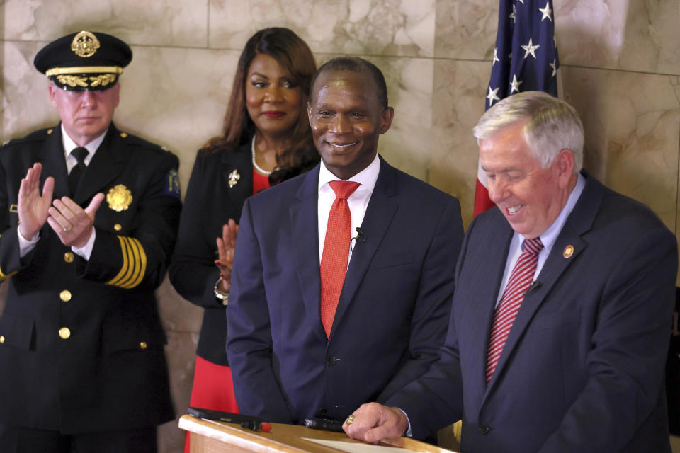Gabe Gore, center, smiles as Gov. Mike Parson, right, announces that Gore will be the new St. Louis Circuit Attorney, replacing Kimberly M. Gardner, during a press conference on Friday, May 19, 2023 at the Carnahan Courthouse in St. Louis. Also pictured are St. Louis Police chief Robert Tracy, left, and St. Louis Mayor Tishaura O. Jones. (David Carlson/St. Louis Post-Dispatch via AP)