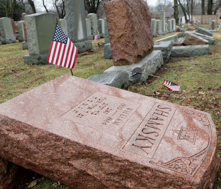 An American flag still stands next to one of over 170 toppled Jewish headstones after a weekend vandalism attack on Chesed Shel Emeth Cemetery in University City, a suburb of St Louis, Missouri, U.S. February 21, 2017. REUTERS/Tom Gannam