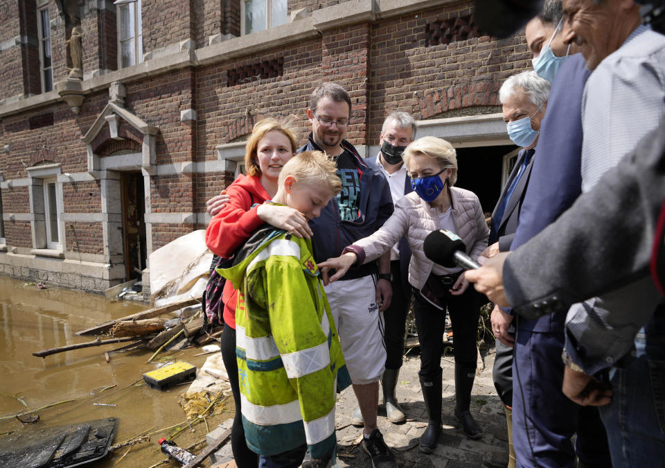 European Commission President Ursula von der Leyen, center, speaks with Madeline Brasseur, 37, Paul Brasseur, 42, and their son Samuel, 12 as she tours the village after flooding in Pepinster, Belgium, Saturday, July 17, 2021. Residents in several provinces were cleaning up after severe flooding in Germany and Belgium turned streams and streets into raging torrents that swept away cars and caused houses to collapse. (AP Photo/Virginia Mayo)