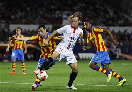 Sevilla's Ivan Rakitic (C) fights for the ball Valencia's Javier Fuego (2nd L) during their Europa League semi-final first leg soccer match in Seville, April 24, 2014. REUTERS/Marcelo del Pozo