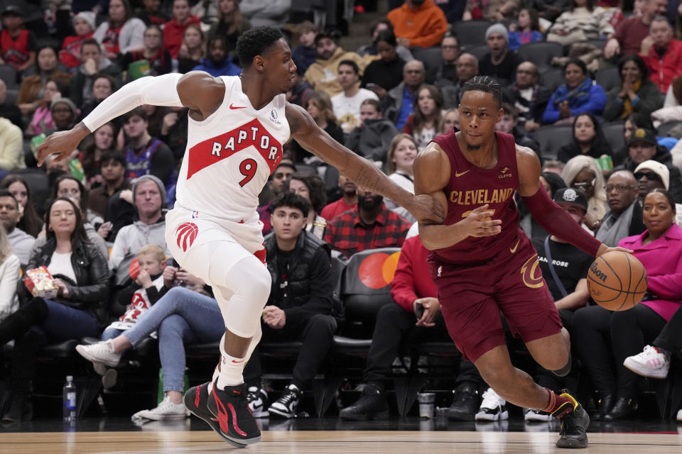 Toronto Raptors guard RJ Barrett (9) defends as Cleveland Cavaliers forward Isaac Okoro (35) drives with the ball during the second half of an NBA basketball game in Toronto, Monday, Jan. 1, 2024. (Chris Young/The Canadian Press via AP)