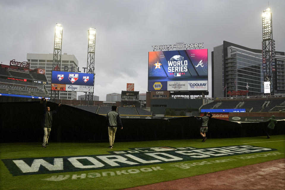 Workers cover the field before Game 3 of baseball's World Series between the Houston Astros and the Atlanta Braves Friday, Oct. 29, 2021, in Atlanta. (AP Photo/Ashley Landis)