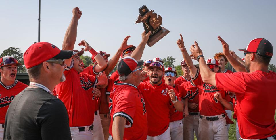 New Boston Huron hoists the District championship trophy after surviving a 10-inning battle with Airport to win 4-1 Saturday.