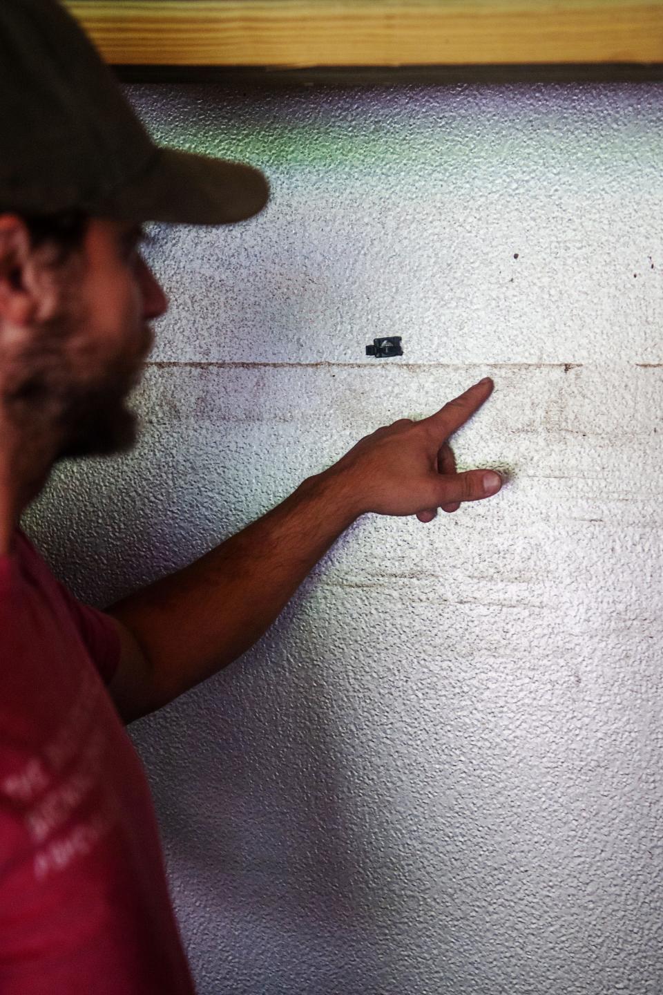 Robert Lemery, founder of The River Arts District Brewing Company, points to the line left by floodwaters, July 29, 2024.