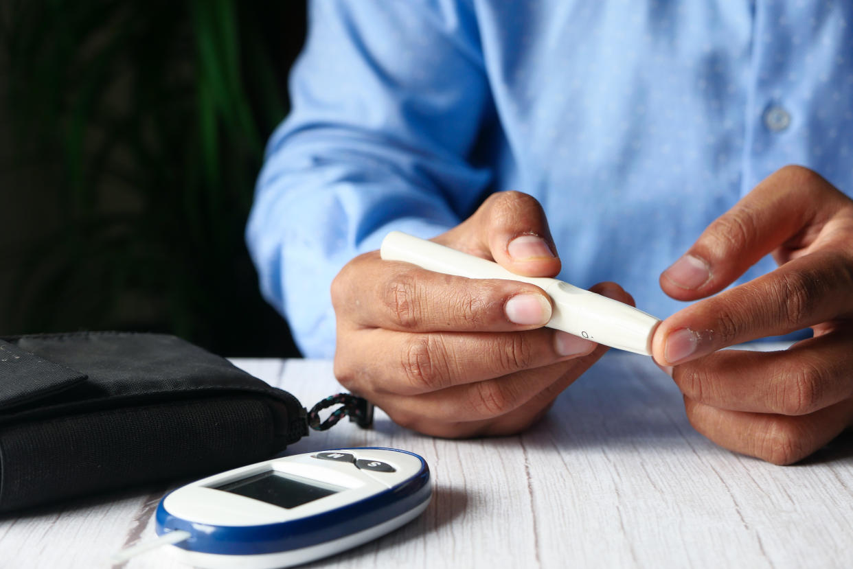 young man hand measuring diabetic on table.