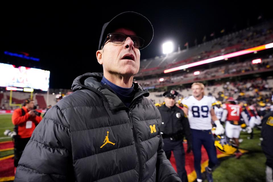 Michigan head coach Jim Harbaugh walks on the field after an NCAA college football game against Maryland, Saturday, Nov. 20, 2021, in College Park, Md. Michigan won, 59-18.