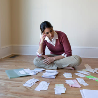 Woman-looking-at-bills-and-receipts-on-the-floor_web