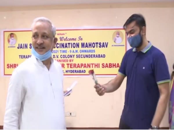 Member of Jain community offering rose to a beneficiary of vaccination drive (Photo/ANI)