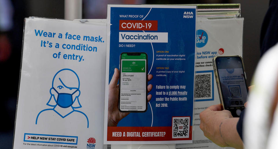 A person checks in with their mobile phone using a Covid QR code.