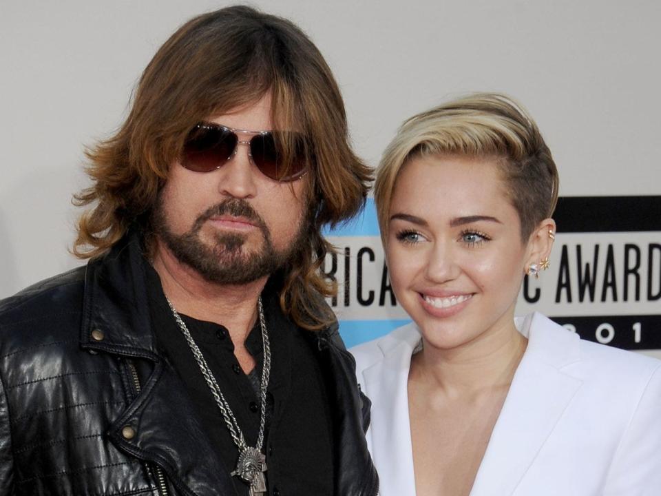 miley and billy ray cyrus on a red carpet