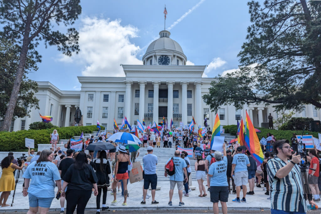 Protesters stand in from of the state building advocating against anti-LGBTQ+ legislation.