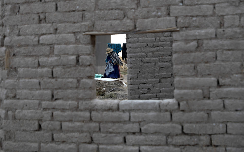 A resident removes her dried laundry from a clothesline in the Urus del Lago Poopo indigenous community, in Punaca, Bolivia, Sunday, May 23, 2021. “Our grandfathers thought the lake would last all their lives, and now my people are near extinction because our source of life has been lost," said Luis Valero, leader of the Uru communities around the lake. (AP Photo/Juan Karita)