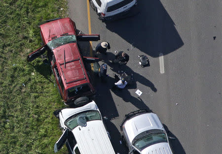 Law enforcement personnel investigate the scene where the Texas bombing suspect blew himself up on the side of a highway north of Austin in Round Rock, Texas, U.S., March 21, 2018. REUTERS/Loren Elliott