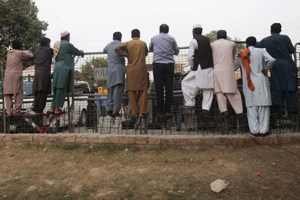 People scramble over the barriers as vehicles (not pictured) escort former Prime Minister Imran Khan, injured after a shooting during a long march in Wazirabad, as they drive off after being discharged from Shaukat Khanum Memorial Cancer Hospital & Research Center, in Lahore, Pakistan 6 November 2022. REUTERS / Mohsin Raza