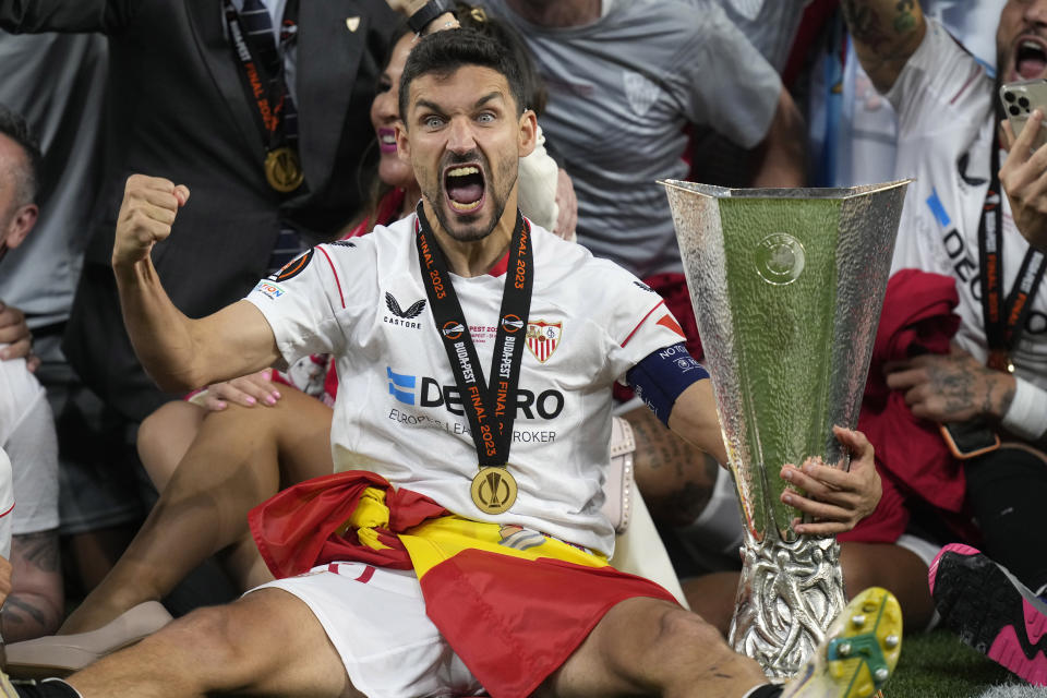 Sevilla's Jesus Navas holds the winners trophy as he celebrates with teammates after winning the Europa League final soccer match against Roma at the Puskas Arena stadium in Budapest, Hungary, Thursday, June 1, 2023. Sevilla defeated Roma 4-1 in a penalty shootout after the match ended tied 1-1. (AP Photo/Darko Bandic)