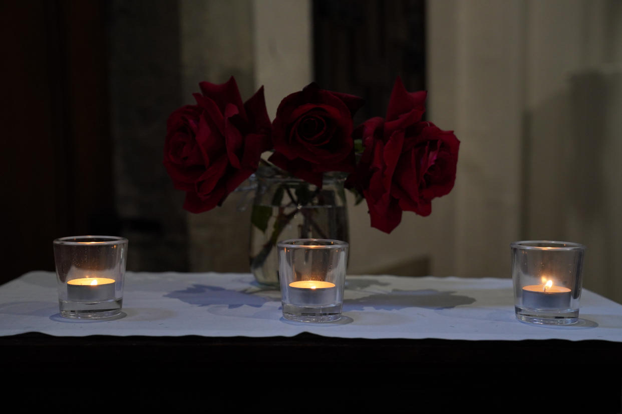 Three candles burn as members of the public attend a morning service and vigil at St James's church in Bushey. (PA)