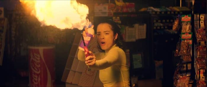 A girl flaring a flame by spraying alcohol on the flame.