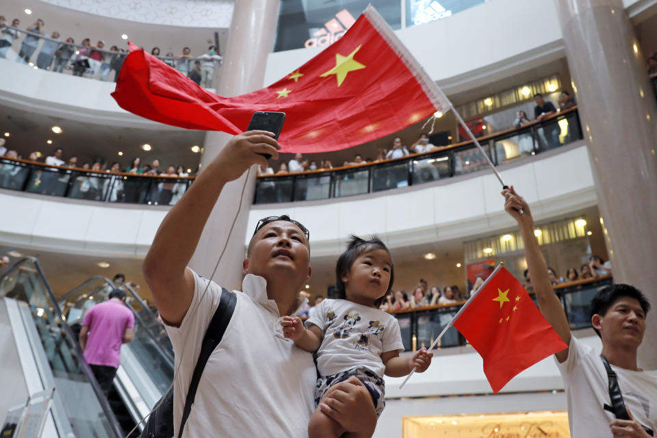 Pro-China supporters wave Chinese national flag in a shopping mall in Hong Kong, Wednesday, Sept. 18, 2019. Activists involved in the pro-democracy protests in Hong Kong appealed to U.S. lawmakers Tuesday to support their fight by banning the export of American police equipment that is used against demonstrators and by more closely monitoring Chinese efforts to undermine civil liberties in the city. (AP Photo/Kin Cheung)