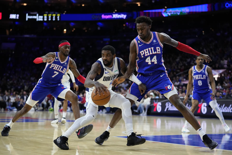 Dallas Mavericks' Kyrie Irving, center, tries to get past Philadelphia 76ers' Paul Reed, right, and Jalen McDaniels during the first half of an NBA basketball game, Wednesday, March 29, 2023, in Philadelphia. (AP Photo/Matt Slocum)