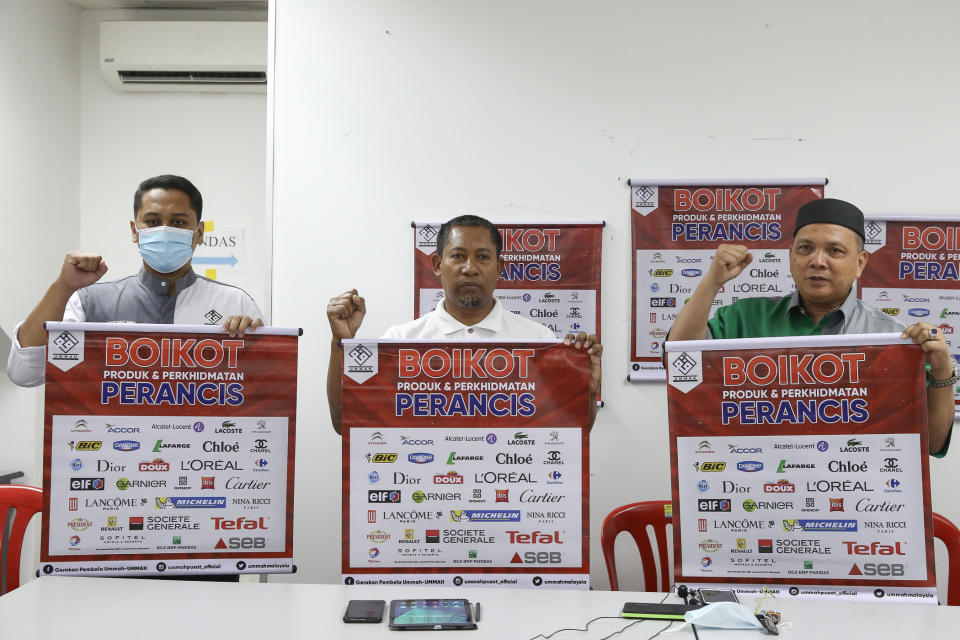 Ummah chairman Mohd Zai Mustafa (centre) poses for a group picture as they hold up placards to boycott French goods and services in Kuala Lumpur November 1, 2020. — Picture by Yusof Mat Isa