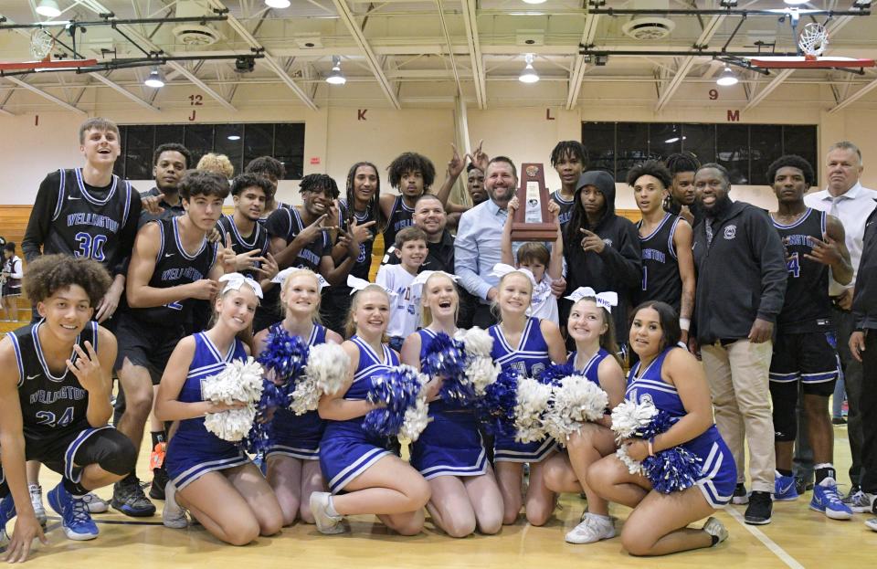 Wellington's boys basketball squad, coaches, and cheerleaders pose for a celebratory photo after the team clinched the district title on Friday. Wellington defeated Lake Worth 82-63 at Santaluces for the 7A-District 11 finale on Feb. 11, 2022.