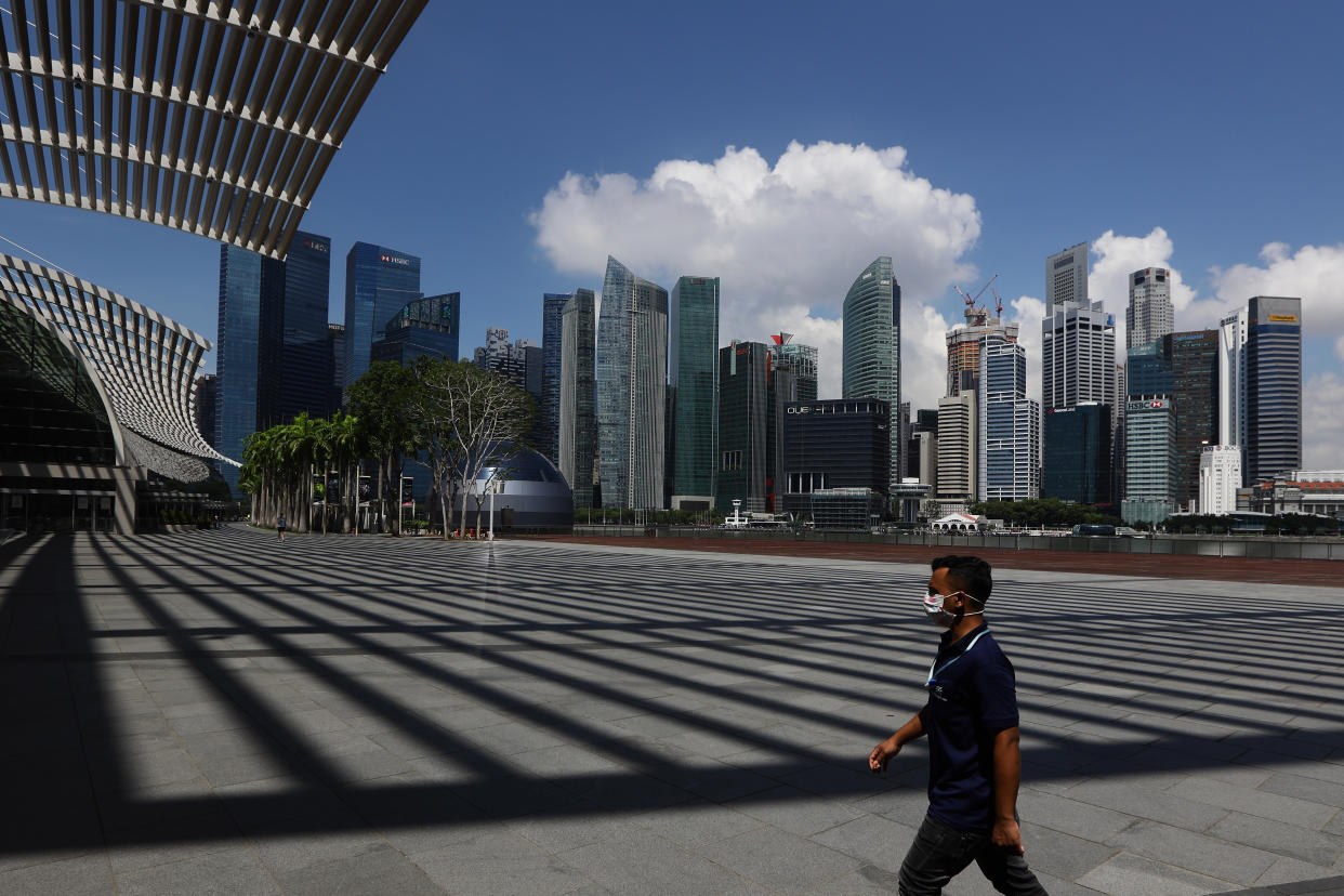 A man wearing protective mask walks at Marina Bay Sands with the Central Business District seen in the background. (Photo by Suhaimi Abdullah/Getty Images)