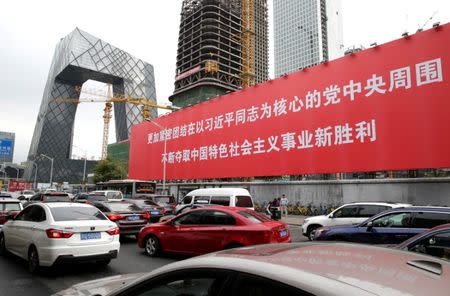 A giant banner is seen in Beijing's central business area, as the capital prepares for the 19th National Congress of the Communist Party of China, October 14, 2017. The words on the banner read, "Unite closely around the Party Central Committee with Comrade Xi Jinping as the core, constantly win new victory for socialism with Chinese characteristics". REUTERS/Jason Lee