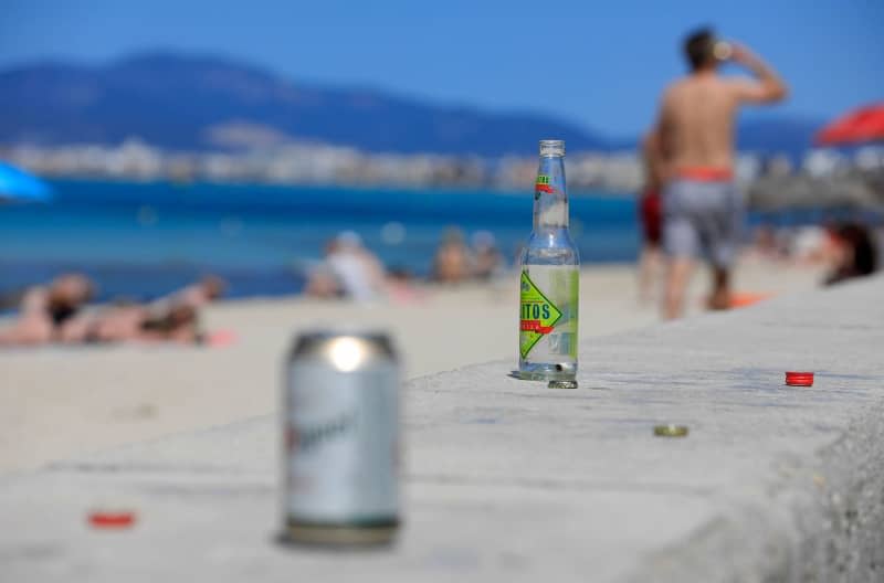 Empty bottles and cans can be seen on Arenal beach in Palma, Mallorca. Mallorca and Ibiza, two Spanish islands known for beach holidays and raucous parties, are cracking down on street drinking in an effort to tame anti-social behaviour by sun-seeking tourists. Clara Margais/dpa