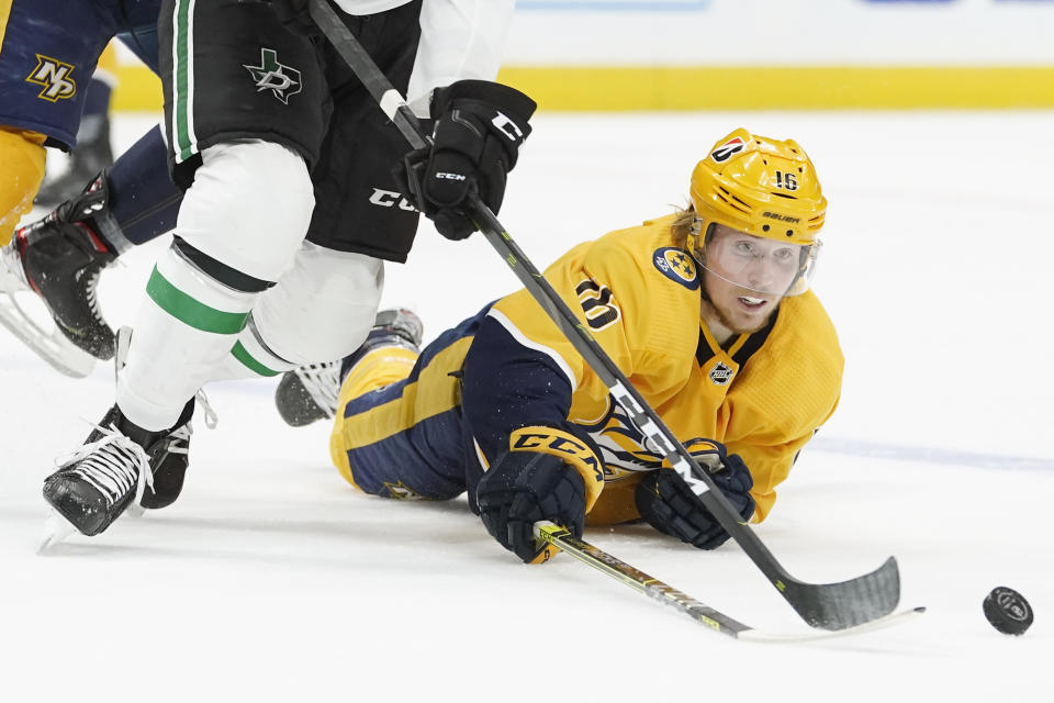 Nashville Predators center Rem Pitlick (16) reaches for the puck as he falls in the second period of an NHL hockey game between the Predators and the Dallas Stars Sunday, April 11, 2021, in Nashville, Tenn. (AP Photo/Mark Humphrey)