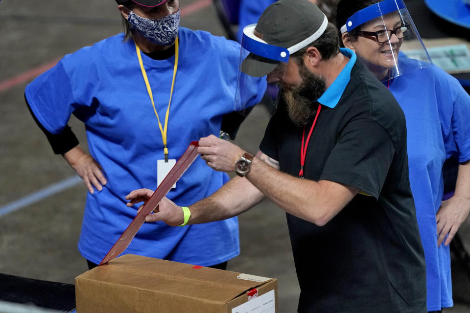 Maricopa County ballots cast in the 2020 general election are unsealed to be examined and recounted by contractors working for Florida-based company, Cyber Ninjas, Thursday, May 6, 2021 at Veterans Memorial Coliseum in Phoenix. The audit, ordered by the Arizona Senate, has the U.S. Department of Justice saying it is concerned about ballot security and potential voter intimidation arising from the unprecedented private recount of the 2020 presidential election results. (AP Photo/Matt York, Pool)