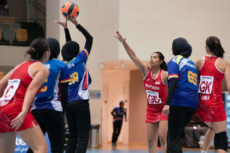 Akira Anding, vice-captain of the Singapore national netball team, attempts to block a Malaysian player's shot during the third Test match at Our Tampines Hub.  (Photo: Netball Singapore)