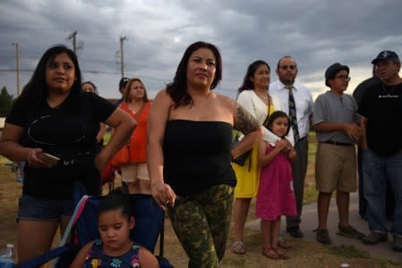 People gather for a vigil a day after a mass shooting in El Paso