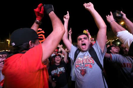 Fan Elior Ilishah celebrates during the San Francisco Giants win over the Kansas City Royals in the World Series during a television viewing event at the Civic Center in San Francisco, California October 29, 2014. REUTERS/Robert Galbraith
