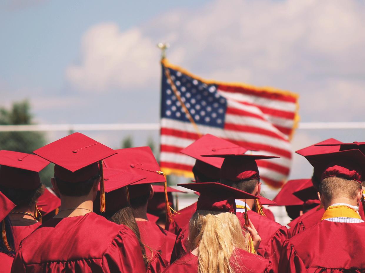 College graduates in front of American flag