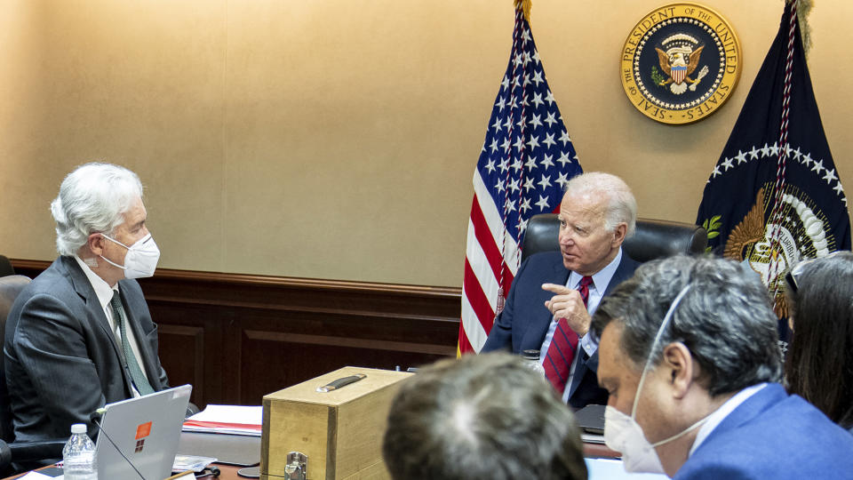 A photo provided and digitally altered by the White House shows President Biden meeting with CIA Director William Burns, left, wearing a mask, and other CIA and National Security advisers, also wearing masks, about al-Qaida leaders. President Biden is not wearing a mask.