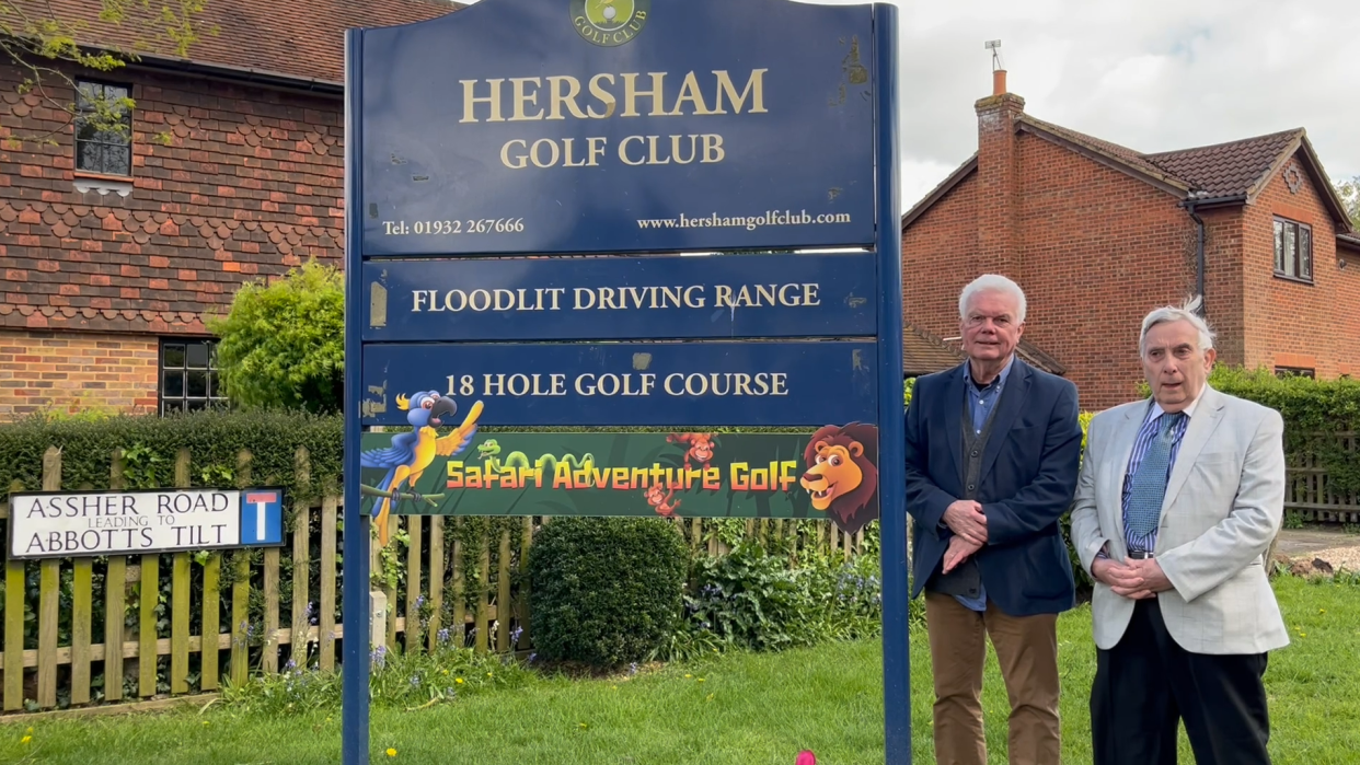 A Hersham Golf Club sign next to which are standing Roy Green and Stephen Foster