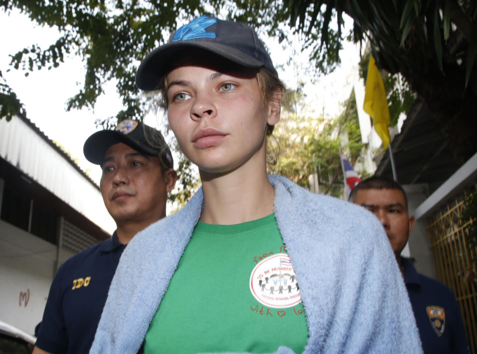 Belarusian model Anastasia Vashukevich is escorted by Thai Immigration police officers from the Immigration Detention Center towards a vehicle to take her to an airport for deportation in Bangkok, Thailand, Thursday, Jan. 17, 2019. Thai officials say they are deporting Vashukevich who claimed last year that she had evidence of Russian involvement in helping elect Donald Trump president. (AP Photo/Sakchai Lalit)