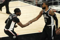 Los Angeles Clippers guard Reggie Jackson, left, congratulates guard Paul George after George scored during the second half of an NBA basketball game against the Minnesota Timberwolves Sunday, April 18, 2021, in Los Angeles. (AP Photo/Mark J. Terrill)
