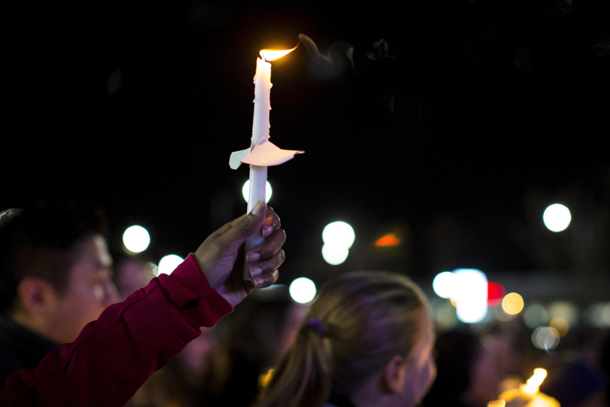 A candle is lifted into the air as residents of Newport News hold a candlelight vigil in honor of Richneck Elementary School first-grade teacher Abby Zwerner at the School Administration Building in Newport News, Va., Monday, Jan. 9, 2023. Zwerner was shot and wounded by a 6-year-old student while teaching class on Friday, Jan. 6. (AP Photo/John C. Clark)