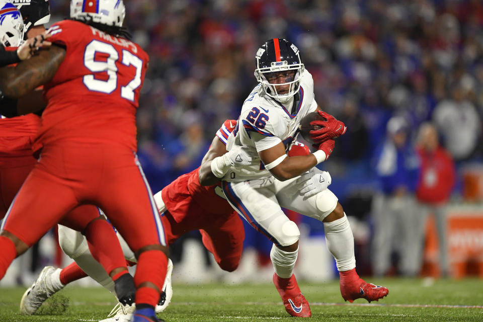 New York Giants running back Saquon Barkley tries to break free on a rush against the Buffalo Bills during the first half of an NFL football game in Orchard Park, N.Y., Sunday, Oct. 15, 2023. (AP Photo/Adrian Kraus)