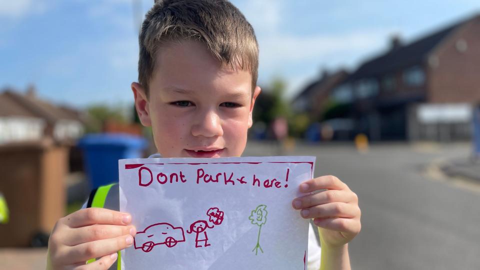 Boy holding a poster about parking